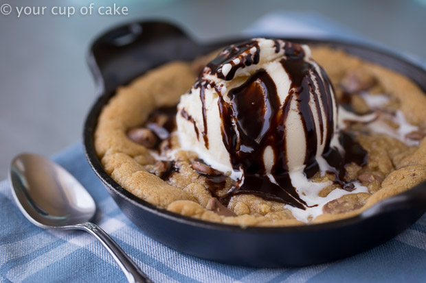 Gooey and rich Brown Butter Pizookie topped with ice cream and chocolate syrup is the perfect dessert for cookie dough lovers!